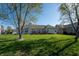 Expansive backyard featuring a lush lawn, mature trees, and a back patio at 1927 Westminster Pl, Columbus, IN 47201