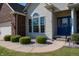 Close up of a charming front entrance featuring manicured bushes and a blue front door at 1927 Westminster Pl, Columbus, IN 47201