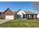 Charming brick and vinyl home featuring a well-manicured lawn and a blue front door at 1927 Westminster Pl, Columbus, IN 47201