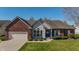 Charming brick and vinyl home featuring a well-manicured lawn and a blue front door at 1927 Westminster Pl, Columbus, IN 47201
