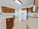Well-lit kitchen featuring ample wood cabinetry, white appliances, and a large sink at 1927 Westminster Pl, Columbus, IN 47201