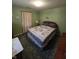 Cozy green bedroom featuring bed, nightstand, and carpet at 2018 Poplar St, Anderson, IN 46012