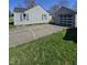 Features a cracked concrete driveway leading to a detached garage with a unique windowed garage door at 2018 Poplar St, Anderson, IN 46012