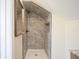 Modern bathroom features a tiled walk-in shower with a recessed shelf and brushed bronze fixtures at 2216 Bethel Ave, Indianapolis, IN 46203