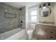 Updated bathroom featuring gray tiled shower, a wooden vanity, and modern fixtures at 2216 Bethel Ave, Indianapolis, IN 46203
