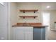 Well-lit kitchen area with stainless steel dishwasher, floating shelves, and wood countertops at 2216 Bethel Ave, Indianapolis, IN 46203