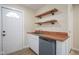 A wet bar featuring a dishwasher, sink, butcher block counter, and floating shelves at 2216 Bethel Ave, Indianapolis, IN 46203