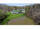 An aerial view showcasing a serene pond and a well-maintained home with lush greenery at 2455 Lenvoil Rd, Martinsville, IN 46151