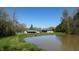 Scenic view of a tranquil pond, house, and garage amidst green landscaping, offering a peaceful retreat at 2455 Lenvoil Rd, Martinsville, IN 46151