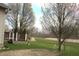 Expansive backyard featuring a swing set, deck and path surrounded by trees and manicured lawn at 2599 Liatris Dr, Plainfield, IN 46168