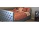 Comfortable bedroom featuring a gray upholstered bed with decorative pillows and a patterned bedspread at 2599 Liatris Dr, Plainfield, IN 46168