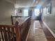 Upstairs hallway with wood floors, wood railing, a runner, natural light, and neutral walls at 2599 Liatris Dr, Plainfield, IN 46168