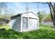 Detached garage with roll-up door and adjacent storage shed in a grassy backyard at 30 Sleepy Hollow Ct, Westfield, IN 46074