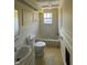 Bathroom view with a white tub, tile surround, and neutral decor at 3010 Lake Shore Dr # D, Indianapolis, IN 46205