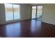 Sunny living room featuring hardwood floors, water view, and sliding glass door to balcony at 3010 Lake Shore Dr # D, Indianapolis, IN 46205