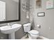 Cozy half-bath features a pedestal sink and decorative wall art at 3038 Arrowroot Ln, Indianapolis, IN 46239