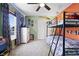A well-lit bedroom with bunk beds, a large window, a ceiling fan, and closet, offering a comfortable and playful space at 3038 Arrowroot Ln, Indianapolis, IN 46239