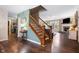 Inviting entryway featuring hardwood floors, staircase, and a glimpse into the adjacent living spaces at 3038 Arrowroot Ln, Indianapolis, IN 46239