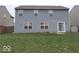 The backyard features a spacious lawn, gray siding, and a sliding glass door that leads to the house at 3097 Limber Pine Dr, Whiteland, IN 46184