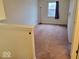 Upstairs bedroom with clean walls and neutral carpeting, bathed in light from the single paned window with blue curtain at 3097 Limber Pine Dr, Whiteland, IN 46184