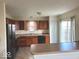 Efficient kitchen features wood cabinets, modern black appliances, and a tile floor for easy cleaning and maintenance at 3097 Limber Pine Dr, Whiteland, IN 46184