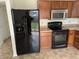 Functional kitchen with black appliances, including a refrigerator, stove, and microwave at 3097 Limber Pine Dr, Whiteland, IN 46184