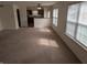 Bright and open living room with neutral carpet, offering seamless flow into the kitchen at 3097 Limber Pine Dr, Whiteland, IN 46184