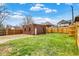 Backyard featuring a small brick building, wooden fence, grassy area, and blue sky at 3140 N Washington Blvd, Indianapolis, IN 46205