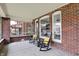 Cozy screened-in porch with rocking chairs, views of the yard, and vintage brick accents at 3140 N Washington Blvd, Indianapolis, IN 46205