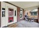 Charming entryway on the screened porch with seating and a view of the neighborhood at 3140 N Washington Blvd, Indianapolis, IN 46205