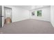 Bright bedroom with two windows, neutral carpet, white walls, and an open doorway to the hallway at 3316 Eden Way Cir, Carmel, IN 46033