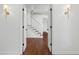 Elegant foyer with hardwood floors, a staircase with white risers, and modern lighting at 3316 Eden Way Cir, Carmel, IN 46033