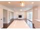 Open living room featuring a fireplace, white trim, hardwood floors, and sliding doors at 3316 Eden Way Cir, Carmel, IN 46033