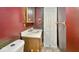 Bathroom with red painted walls, sink and toilet; storage cabinet, and light wood trim at 3346 S Lockburn St, Indianapolis, IN 46221
