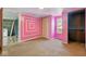 Bedroom with pink walls and a nearby laundry area, carpet flooring and window letting in natural light at 3346 S Lockburn St, Indianapolis, IN 46221