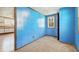 Bedroom with blue wood paneled walls, carpet flooring and window letting in natural light at 3346 S Lockburn St, Indianapolis, IN 46221