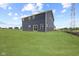 Exterior of new two-story home showcasing dark siding, a sliding glass door, and a spacious backyard at 338 Mcnair Dr, Whiteland, IN 46184