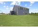Back exterior of home with dark siding, sliding glass door and large backyard at 338 Mcnair Dr, Whiteland, IN 46184