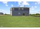 Exterior view of a two-story home highlighting dark siding and a large backyard at 338 Mcnair Dr, Whiteland, IN 46184