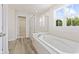 Bathroom with bathtub, glass shower, and large windows offering outside views at 338 Mcnair Dr, Whiteland, IN 46184