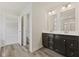 Bathroom with double vanity, dark cabinets, white countertop, and mirrors with decorative sconces above at 338 Mcnair Dr, Whiteland, IN 46184