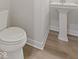 Close-up of a half-bathroom featuring new vinyl flooring and pedestal sink at 338 Mcnair Dr, Whiteland, IN 46184