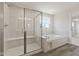 Bright bathroom featuring a glass shower with bench seating and a separate soaking tub with tile surround at 338 Mcnair Dr, Whiteland, IN 46184