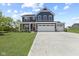 Beautiful two-story home with a three car garage, red door, and manicured lawn on a sunny day at 338 Mcnair Dr, Whiteland, IN 46184