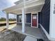 Inviting front porch with white columns, a red door, stone accents and navy blue siding at 338 Mcnair Dr, Whiteland, IN 46184