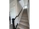 Carpeted stairway with a dark wood banister and white trim at 338 Mcnair Dr, Whiteland, IN 46184
