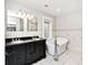 Bathroom features a double vanity with a black countertop, a free-standing tub and stylish white marble tiling at 3544 Guilford Ave, Indianapolis, IN 46205