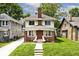 Inviting two-story home featuring brick accents, a cozy front porch, and landscaped lawn at 3544 Guilford Ave, Indianapolis, IN 46205