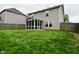 View of backyard with screened porch, grass, and wood fence at 3930 Towhees Dr, Indianapolis, IN 46237