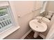 Half bathroom features a pedestal sink, window and towel bar at 3930 Towhees Dr, Indianapolis, IN 46237